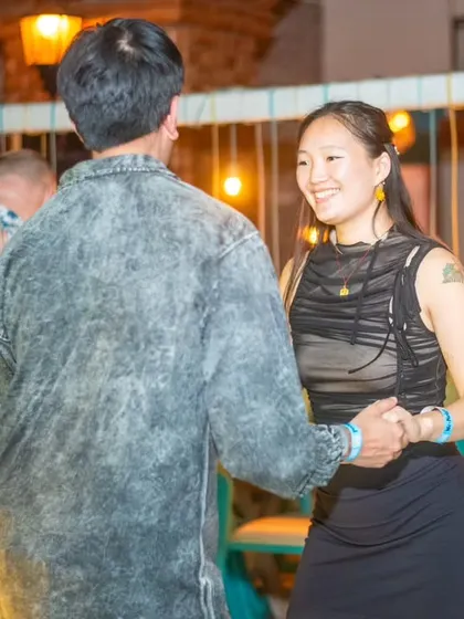 A smiling dancer enjoying the music. The warm lighting and friendly crowd make for a perfect night.