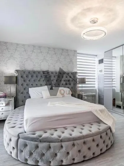 For a truly unique bedroom, consider a statement piece like this round, tufted bed. Paired with mirrored furniture and a textured wallpaper, this design creates a glamorous, Hollywood-regency-inspired look that is pure luxury.
