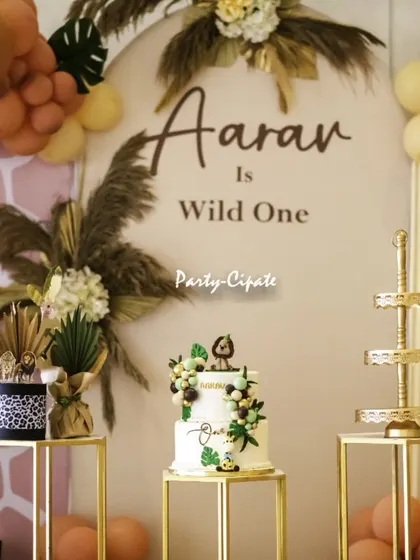 The main backdrop for Aaran's 'Wild One' party, featuring his name in elegant script. The combination of the cake, props, and backdrop creates a perfect focal point.
