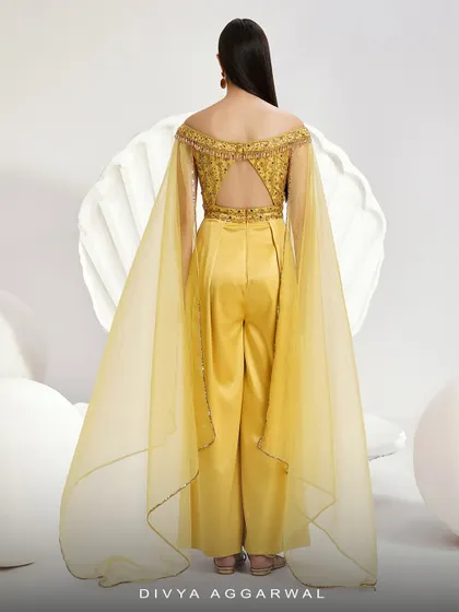 The back of the Emma Jumpsuit, revealing the open-back design and the full, flowing expanse of the organza cape sleeves.