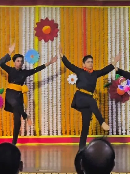 Young students performing on stage at Amity International School. The colorful backdrop adds to the festive atmosphere of the school event.