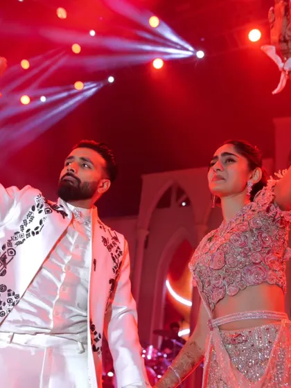 Dancing the night away under the vibrant stage lights. This image captures the high energy and fun of the Sangeet party.