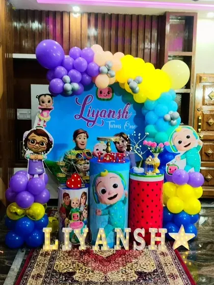 Our Cocomelon theme is a big hit with toddlers. This colorful setup for Liyansh's first birthday includes all the favorite characters, a vibrant balloon arch, and themed pedestals.