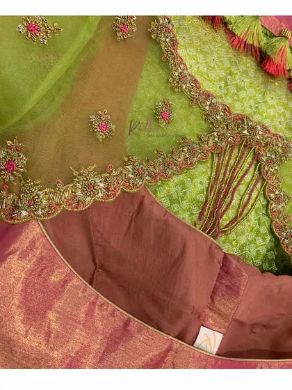 A close-up of the green net blouse, showing the intricate cutwork and embroidery along the back opening.