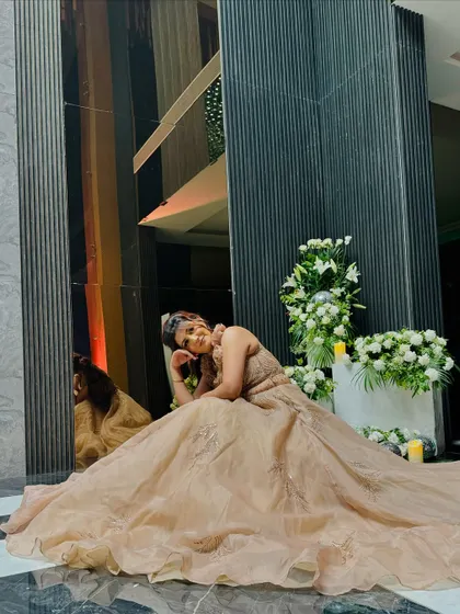 A dramatic pose showcasing the full, flowing skirt of the champagne ball gown. This is an outfit that is made for grand entrances and stunning photos.
