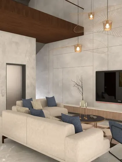 In this living area, I used large-format tiles on the TV wall to create a textured, monolithic look. The wooden ceiling detail adds warmth and contrasts with the cool tones of the tiles and floor. The blue chairs provide a nice splash of color.