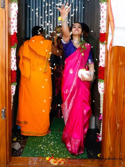 The moment of entering the new home is a highlight of the Griha Pravesh ceremony. We capture this joyous ritual, with the woman tossing flower petals in celebration.