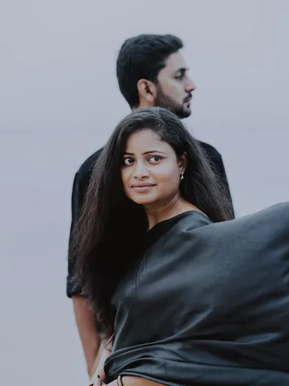 A striking portrait from a pre-wedding shoot, where the woman looks at the camera while her partner stands behind her.