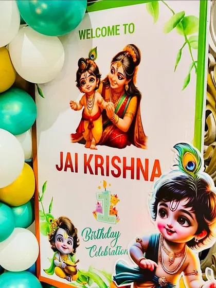 A custom welcome sign for a 'Jai Krishna' themed first birthday. The design incorporates beautiful illustrations of baby Krishna and is framed by a balloon arrangement in a festive color palette.