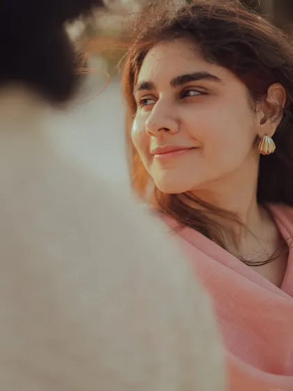 A beautiful over-the-shoulder shot capturing the bride-to-be's soft smile as she looks at her partner.
