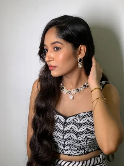 A side profile of the black and white look, showing off the loose curls and the beautiful jewelry.