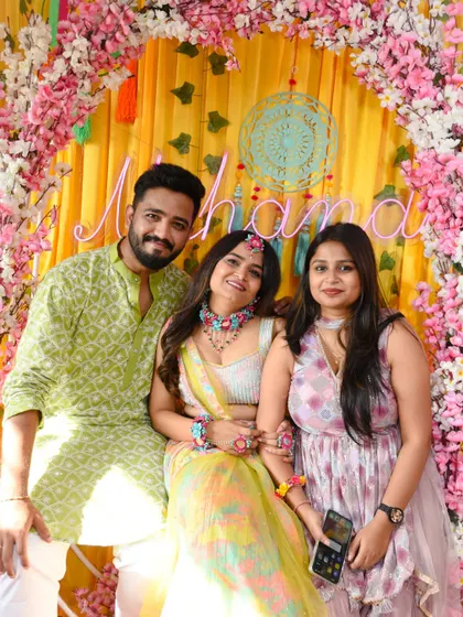 The couple with a guest, all smiles during the vibrant celebration.