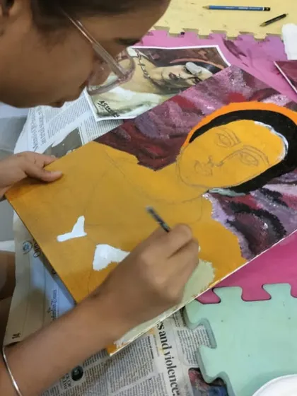 A close-up of the detailed work that goes into creating a portrait. This student is focused on capturing the features and expression, learning valuable acrylic painting techniques along the way.