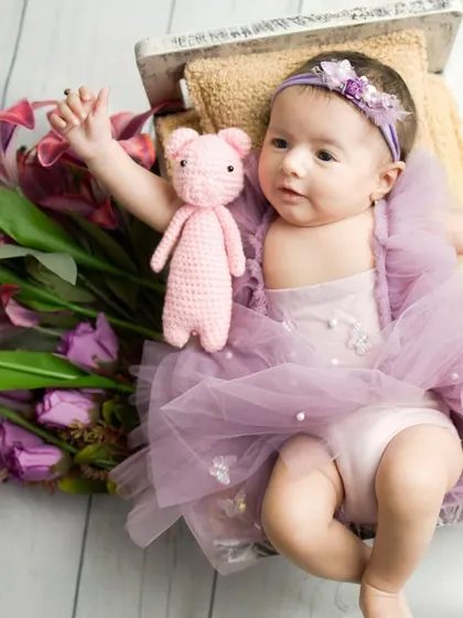 Reaching for the stars, even in her sleep. This pose is so sweet and captures the boundless potential of a new life. The little pink teddy bear adds a touch of extra cuteness.