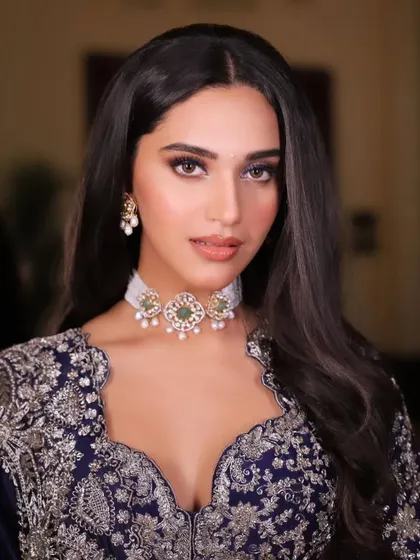 A close-up portrait highlighting the delicate choker and the beautiful scalloped neckline of the blouse.
