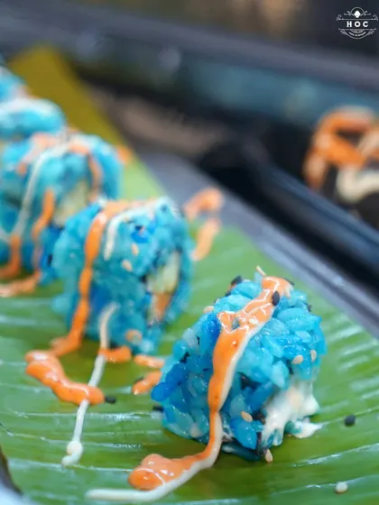 We love to surprise and delight with our global cuisine. This vibrant blue vegetarian sushi, served on a fresh banana leaf, showcases our creative approach to food, ensuring every dish is a conversation starter.