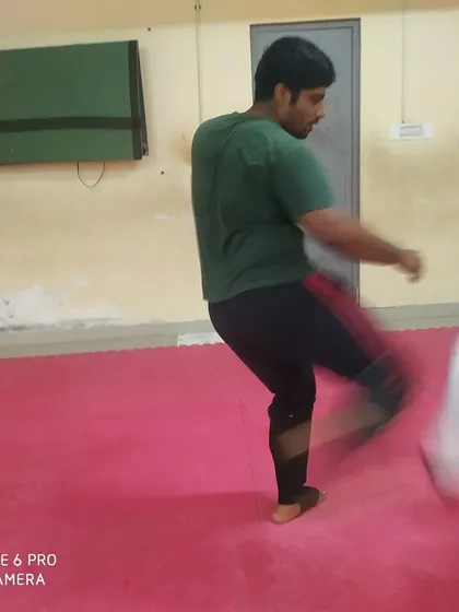 This image captures the motion of a powerful low kick during a training session on the mats at our Raclo Dojo.