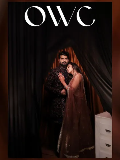 A moody and romantic portrait of the couple, framed by dark curtains, creating a cinematic and intimate feel.