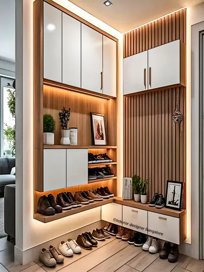 A well-organized, multi-level shoe rack designed for a corner space. The unit includes open shelves for frequently used shoes and closed cabinets for others, all illuminated with integrated lighting.