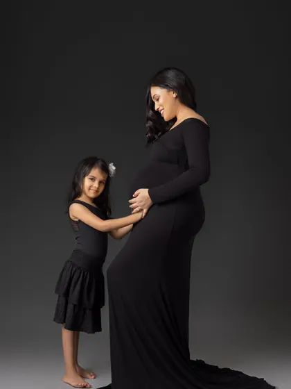 A duplicate of a previous shot, this photo captures a young girl's affection for her unborn sibling as she touches her mother's belly. It's a classic pose for maternity sessions with older children.