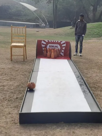 The portable bowling alley game set up at an outdoor venue. It's a great, casual game for guests to play at their own pace during a party.