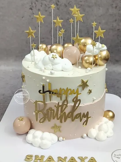 A dusky, starry fault line cake. This two-tone pink and white cake features a fault line filled with stars and is topped with clouds and more star decorations.