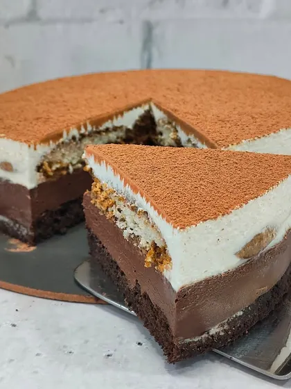 A perfect slice of my Tiramisu Cheesecake. You can see the distinct layers of coffee-soaked biscuits, creamy mascarpone-style filling, and a rich chocolate base.