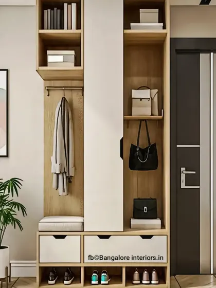 This foyer unit is designed for maximum organization. It includes open shoe cubbies, drawers, a seating bench, a coat rack, and upper shelves, all in a clean, modern wood and white finish.