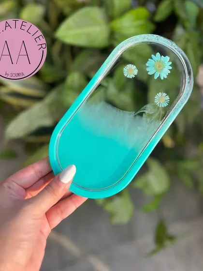 A refreshing aqua-colored oval trinket tray. It's a stylish and practical addition to your home or office.