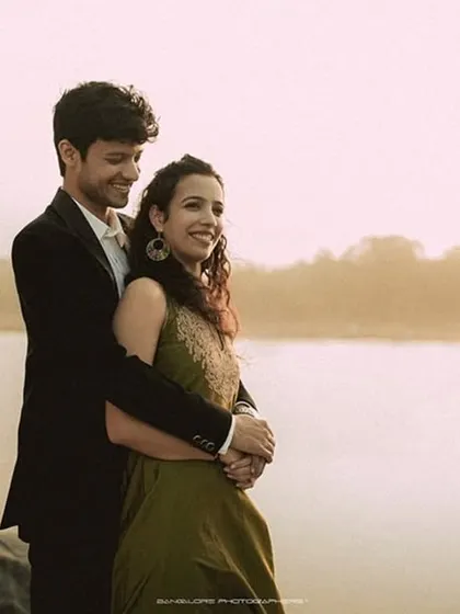An embrace by the lake at sunset. The warm, golden light envelops the couple, creating a dreamy and romantic atmosphere for this pre-wedding portrait.