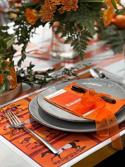 Another detail of the Hermès-themed table, showing the custom-printed placemat and elegantly tied napkin.