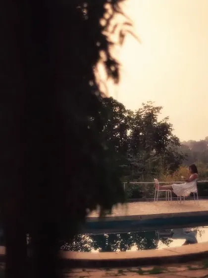 A quiet, peaceful scene of a woman by a pool, framed through a window. This shot demonstrates my use of creative framing and soft, golden light to create a sense of calm and intimacy.