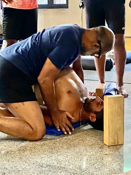 This hands-on assistance helps an athlete achieve a deeper passive backbend, releasing tension in the thoracic spine and improving overall spinal mobility.