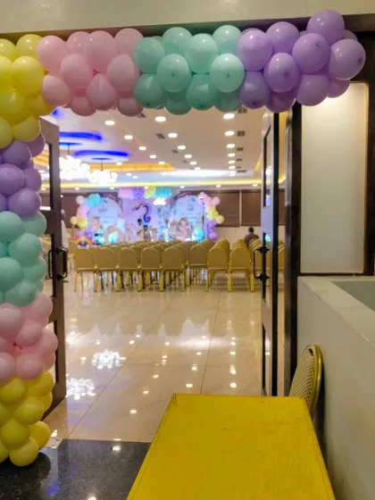 The entrance to a unicorn-themed party with a pastel balloon arch.