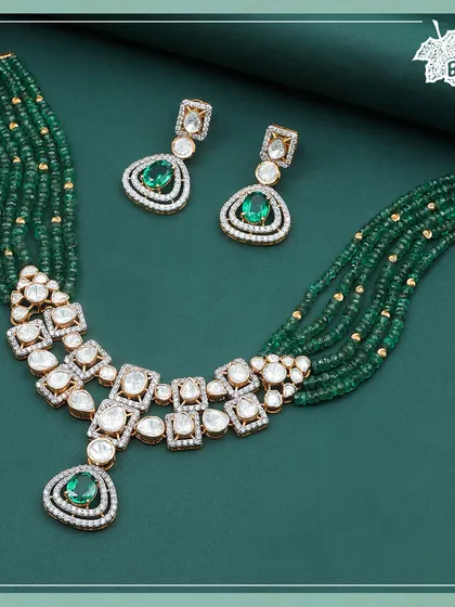 A full view of our Green Grace necklace set. The arrangement of Polki diamonds and emeralds is designed for maximum impact, creating a piece that shines in every celebration. The matching earrings complete the elegant ensemble.
