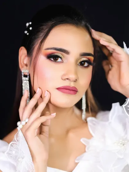 This shot highlights the pearl hair accessories and shimmering earrings that complete the angelic look.