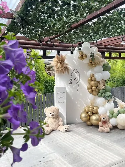 A minimalist and modern baby shower setup that can be ready in just 30 minutes. The simple line art of a pregnant mother, combined with a boho balloon garland, creates a beautiful and quick decor solution.