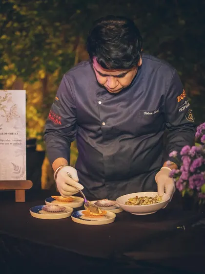 A photo of me, Chef Vikas, carefully plating a dish at an outdoor event.