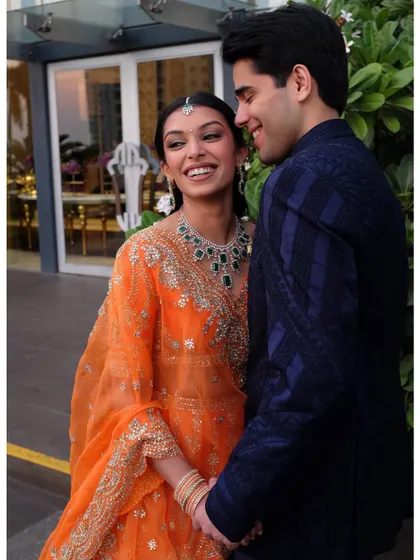 A happy, candid moment between the school friends turned couple. Her makeup is bright and fresh, matching her vibrant outfit.