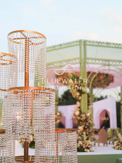 A close-up of the tiered crystal installation, reflecting the pastel colors of the mandap in the background.
