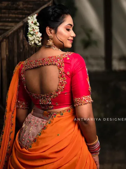 A detailed look at the back of the embroidered red blouse, featuring a stylish cutout design.