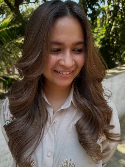 A smiling client loving her new beige hair.