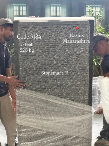 The 5-foot, 520 kg granite waterfall is carefully wrapped in protective material before crating.