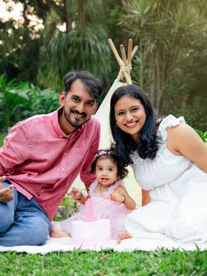 A happy family enjoying a garden cake smash picnic. This photo shows how I can combine a cake smash with beautiful family portraits for a complete birthday celebration.