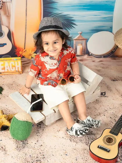 Who needs a real beach when you have the studio? This beach boy theme, complete with sand, surfboards, and a tiny guitar, is perfect for a fun and relaxed toddler shoot.