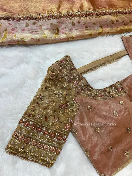 A beautiful dusty rose blouse with heavy floral embroidery on sheer net sleeves.