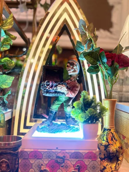 A quirky skeleton statue holding a treasure chest, adding a playful and adventurous touch to our bar decor.