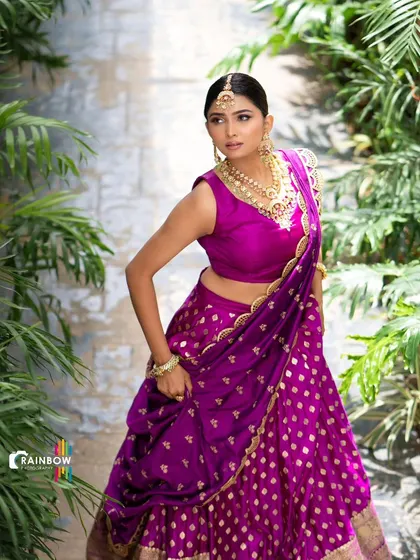 This shot highlights the rich color and texture of the purple half saree, a perfect rental for bridesmaids or wedding guests.