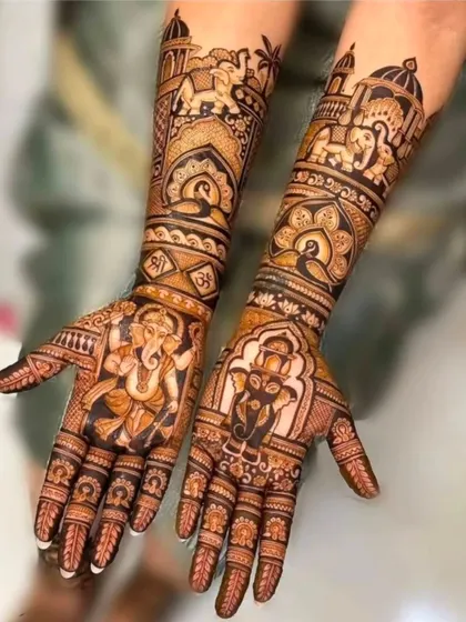 A design centered around blessings, with two distinct Ganesha portraits on the palms, surrounded by royal elephants and palace-inspired architecture.