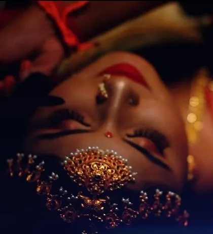 An artistic, top down view of a bride in her full muhurtham glory. The focus is on the stunning maang tikka and the bold red lip, capturing the essence of a traditional South Indian bride.